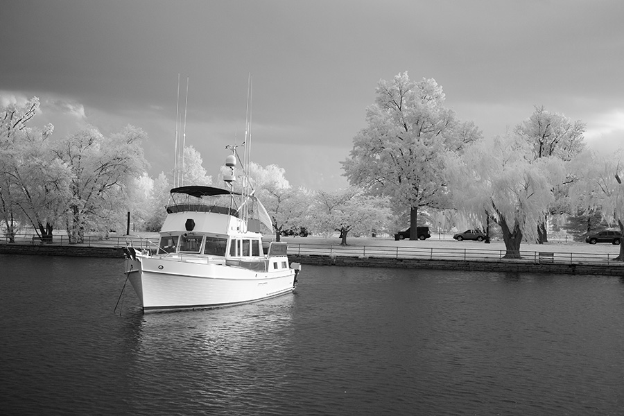 Infrared Photo of Yacht Trawler at Anchor with Trees Behind It.